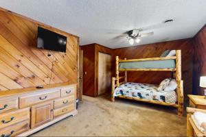 a bedroom with two bunk beds and a flat screen tv at Coos Moose in Ellijay