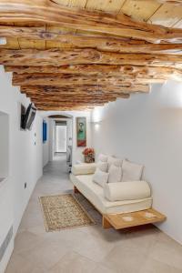 a living room with a white couch and a wooden ceiling at Totem in Ano Syros
