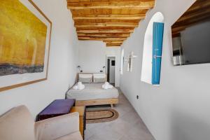 a room with two beds and a tv on a wall at Totem in Ano Syros +49 photos