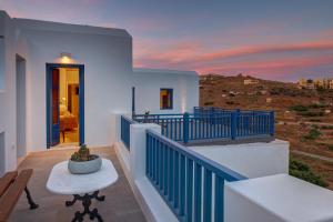 a villa with a balcony with a sunset at Totem in Ano Syros