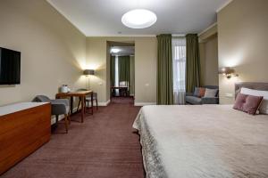 a hotel room with a bed and a living room at D31 Hotel in Odesa