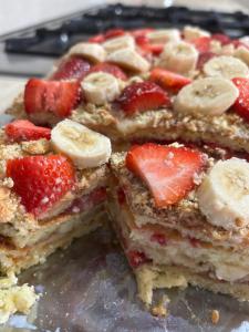 a stack of pancakes with strawberries and bananas on a plate at Rob Guest House in Garni