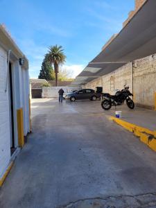 a motorcycle parked in a parking lot with a car at Hotel Plaza San Juan in San Juan