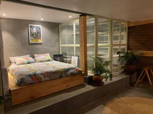 a bedroom with a bed and a large window at Embibi Mindfulness Cabins in Ngong