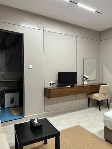 a living room with a tv on a wall at Holiday Homes in Ras al Khaimah
