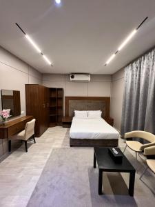a bedroom with a bed and a desk and chairs at Holiday Homes in Ras al Khaimah +34 photos