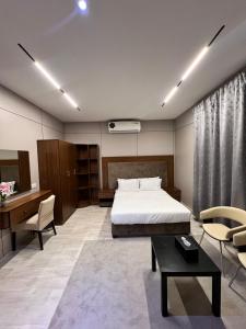 a bedroom with a bed and a desk and chairs at Holiday Homes in Ras al Khaimah