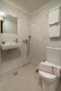 ein weißes Badezimmer mit Toilette und Waschbecken in der Unterkunft Orfeas Hotel in Mytilini + 55 Fotos