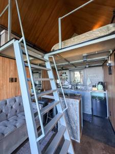 a staircase in a tiny house with a kitchen at Chalé Sattva - Vista Mar e banheira de Hidromassagem quente - Florianópolis - SC - BR in Florianópolis
