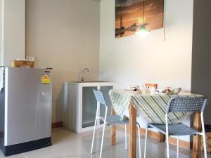 a kitchen with a table and chairs and a refrigerator at Baan Bangrak Residence in Trang +30 photos