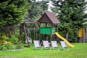 a playground with chairs and a slide at Apartamenty Przystanek Bańska in Bańska Niżna