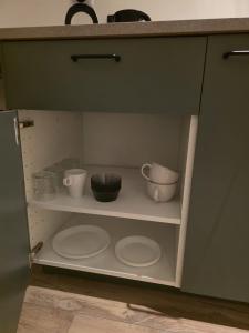 a cupboard with plates and bowls on a shelf at Alpa Farm Rouveen in Rouveen
