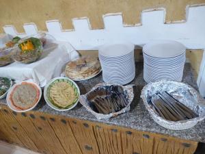 a buffet with plates and bowls of food on a counter at Eva camp in Disah +57 photos
