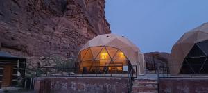 a glass dome building with a rock wall at Eva camp in Disah