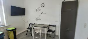 a room with a table and chairs and a clock on the wall at Monterunterkunft Revant WE 2 in Arnstadt