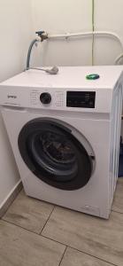 a white washing machine sitting on a floor at Elizabeth in Komárom