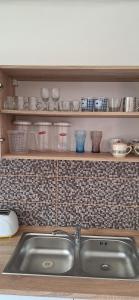 a kitchen with a sink and a shelf with dishes at Elizabeth in Komárom +17 photos