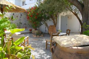 eine Terrasse mit Tisch, Stühlen und Pflanzen in der Unterkunft Tsaner Apartment and Rooms in Matala