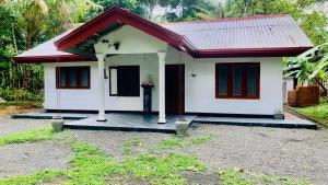 a small white house with a red roof at Mayon villa in Midigama East