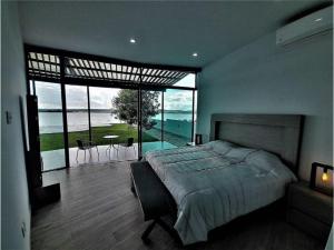 a bedroom with a large bed and a large window at Casa en Lago Rapel, Quebrada Honda in Lago Rapel +36 photos