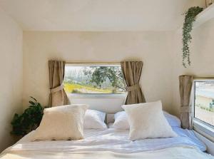 a bedroom with a bed with pillows and a window at SOL Glamping at Khao yai in Ban Nong Makha