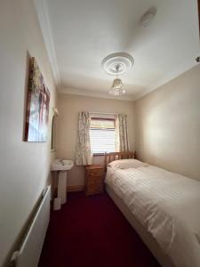 a small bedroom with a bed and a sink at Simple Stay Foxford in Foxford