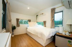 a bedroom with a white bed and a window at SOL Glamping at Khao yai in Ban Nong Makha