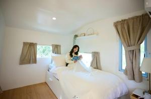 a woman sitting on a bed in a bedroom at SOL Glamping at Khao yai in Ban Nong Makha