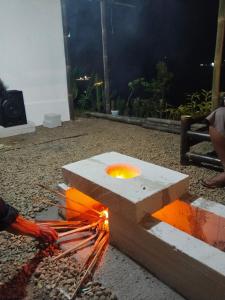 a man is lighting a fire in a stone bench at Cihulu Budget Glamping in Tengahgirang