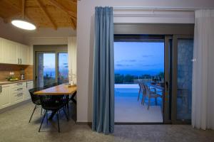 a kitchen and dining room with a table and chairs at Ionian Harmony Luxury Villas in Tsoukalades