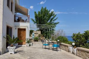 a patio with chairs and tables and the ocean at 180 View Private 2 Bedroom Seaview Home in Samos