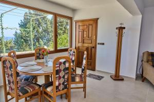 a dining room with a table and chairs and a window at 180 View Private 2 Bedroom Seaview Home in Samos