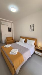 a bedroom with a large bed with towels on it at Drymades Ruci Rooms in Dhërmi