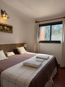 a bedroom with two beds and a window at Apart Hosteria Plaza- La Cumbre in La Cumbre