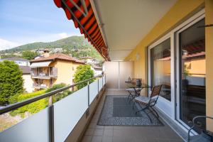 a balcony with a table and a chair on it at Minusio, Casa Gottardo - nahe Zentrum Locarno und See Lago Maggiore, mit Balkon und Parkplatz in Minusio +11 photos