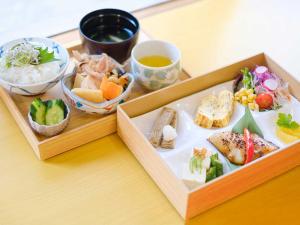 a tray of food with sushi and vegetables on a table at Matsuyama New Grand Hotel in Matsuyama