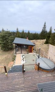a small building with a boat on a deck at Cabană Panoramic Aframe in Dealu Negru