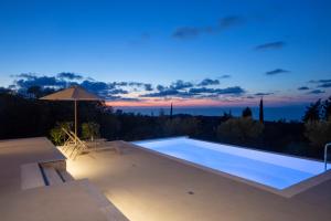 a swimming pool with a sunset in the background at Ionian Harmony Luxury Villas in Tsoukalades +16 photos