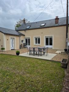 a house with a table and chairs in the yard at Mon Gîte in Château-du-Loir