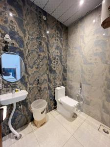 a bathroom with a toilet and a sink and a mirror at Hotel Girraj Inn in Vrindāvan