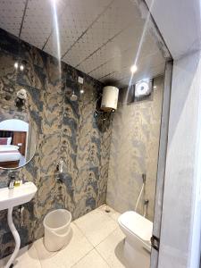 a bathroom with a toilet and a sink at Hotel Girraj Inn in Vrindāvan