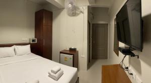 a hotel room with a bed and a television at ON'S Place in Pattaya