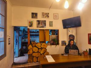 a woman sitting at a table with a laptop at Hostal Perro Watón in Valparaíso
