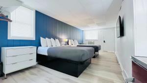 a bedroom with two beds and a blue wall at Motel Luzerne in Lake Luzerne +90 photos