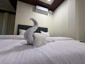 a stuffed elephant is sitting on a bed at Om residency in Diveagar +2 photos
