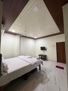 a bedroom with a large bed and a tv on the ceiling at Om residency in Diveagar