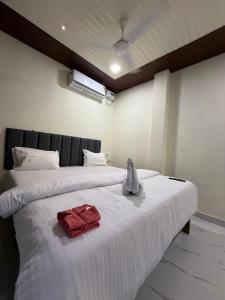 a bed with a stuffed animal sitting on top of it at Om residency in Diveagar
