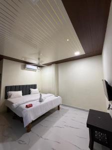 a bedroom with a bed and a television in it at Om residency in Diveagar