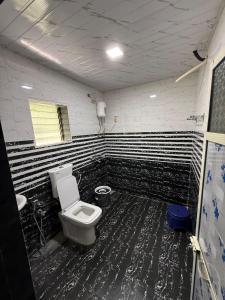 a bathroom with a toilet and black and white stripes at Om residency in Diveagar