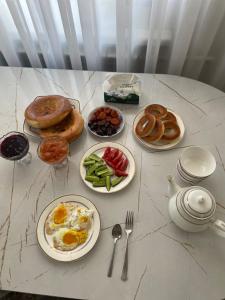 a table with plates of breakfast food on it at Guest Home in Jalal-Abad +11 photos